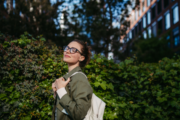 Portrait of young woman enjoying nature in a city park.