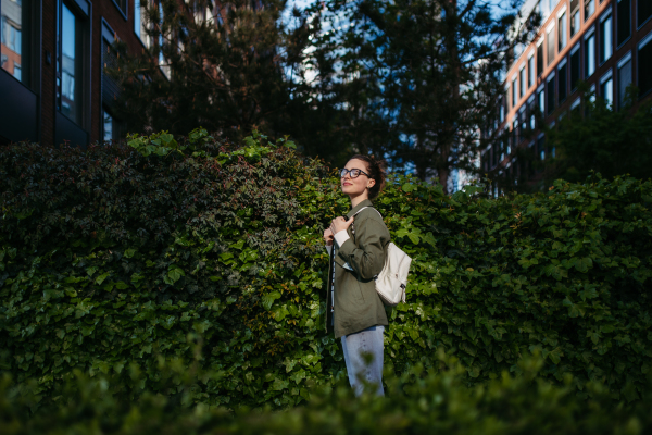 Portrait of young woman enjoying nature in a city park.