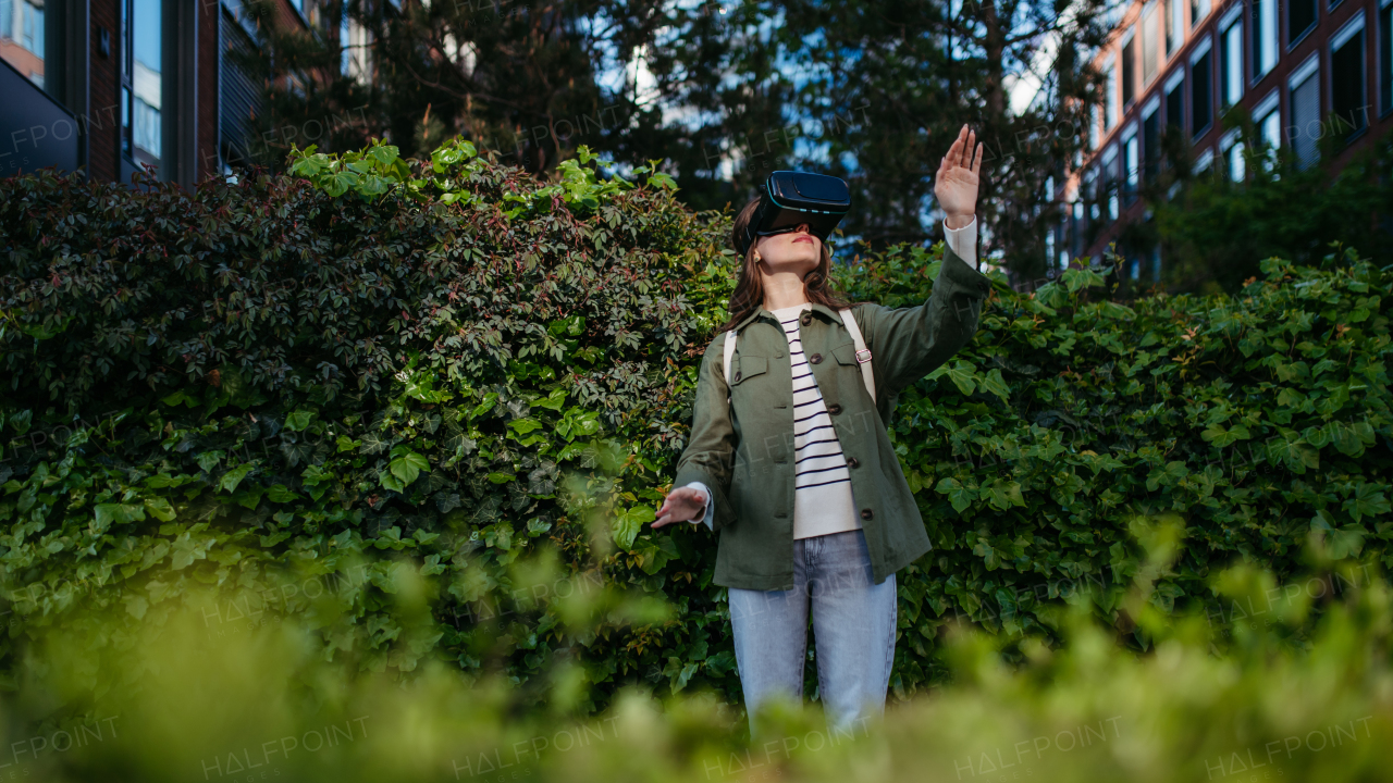 Portrait of happy woman with virtual reality goggles outdoor.