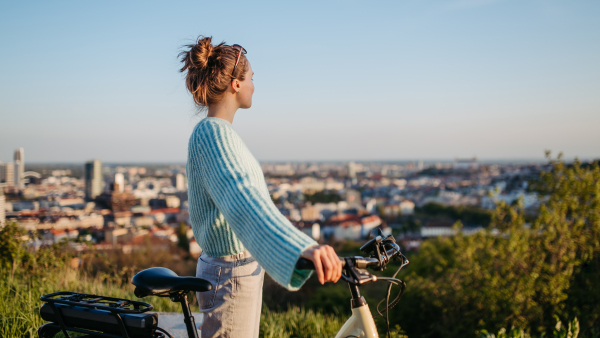 Young woman on an electro bicycle, concept of commuting and ecologic traveling.