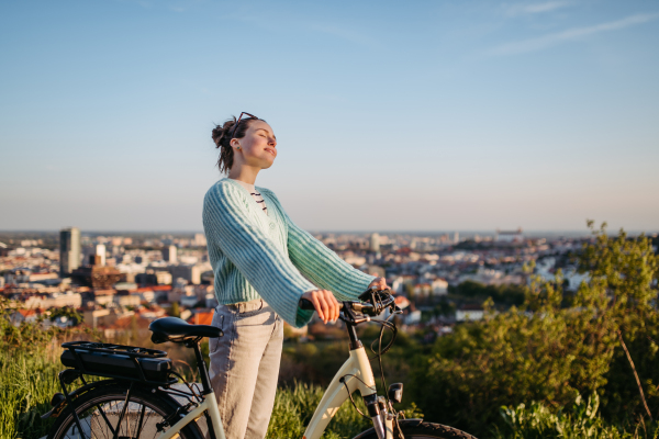 Young woman on an electro bicycle, concept of commuting and ecologic traveling.