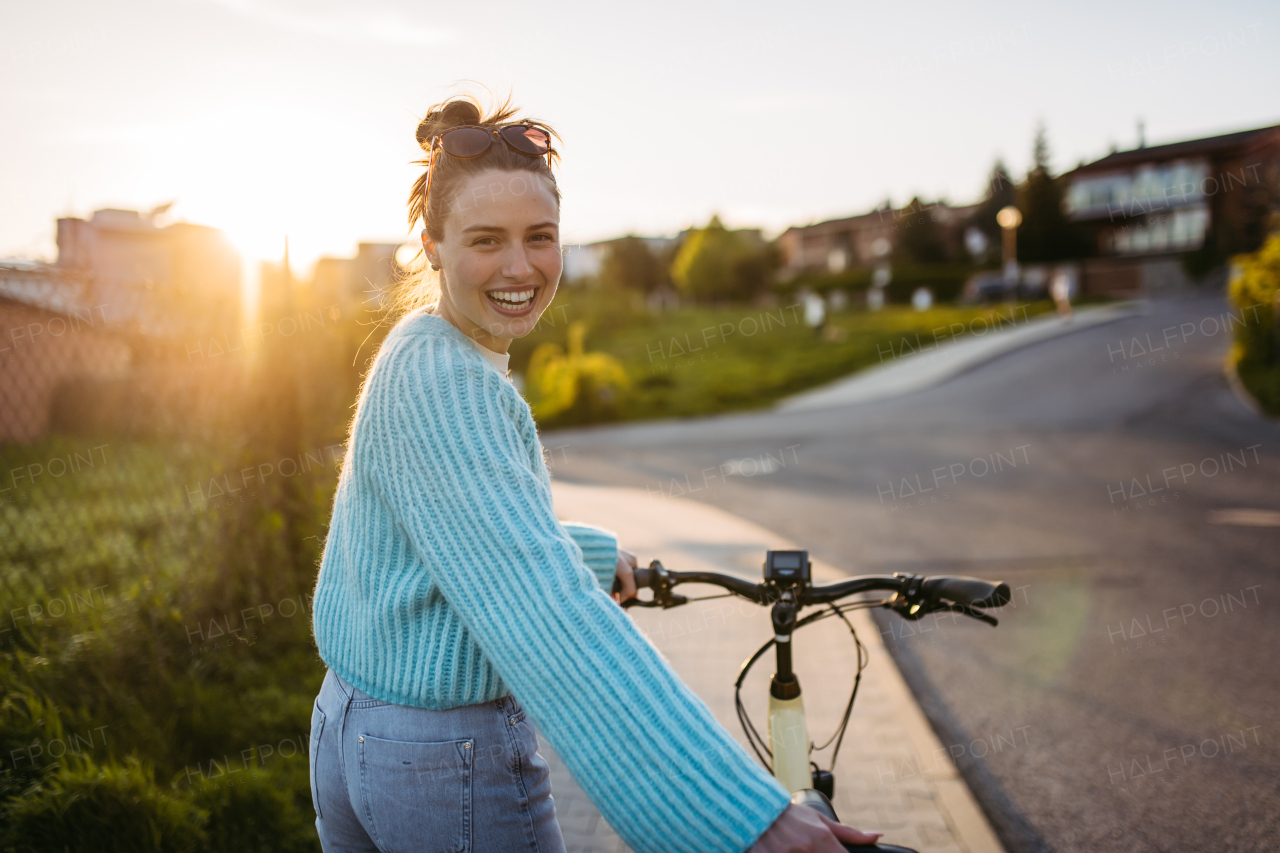 Young woman on an electro bicycle, concept of commuting and ecologic traveling.