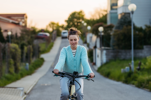 Young woman on an electro bicycle, concept of commuting and ecologic traveling.