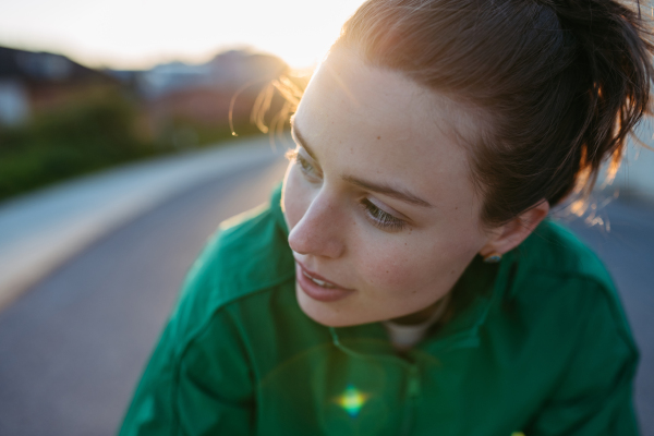 Portrait of young woman in sportive clothes outdoor during sunset.