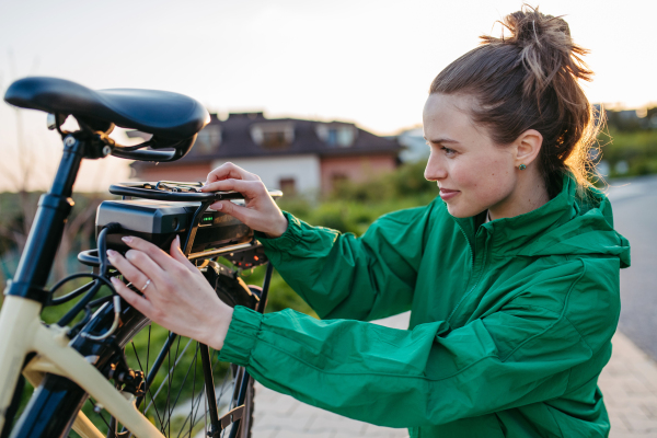 Young woman with an electro bicycle, concept of commuting and ecologic traveling.