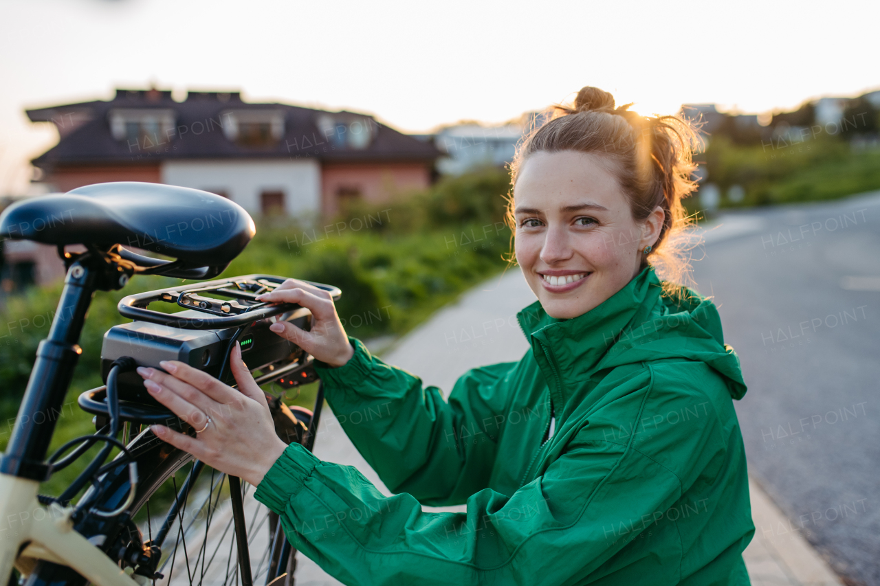 Young woman with an electro bicycle, concept of commuting and ecologic traveling.