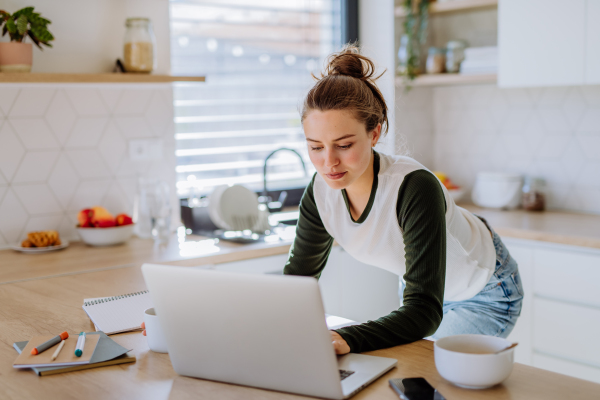 Young woman having homeoffice in a kitchen.