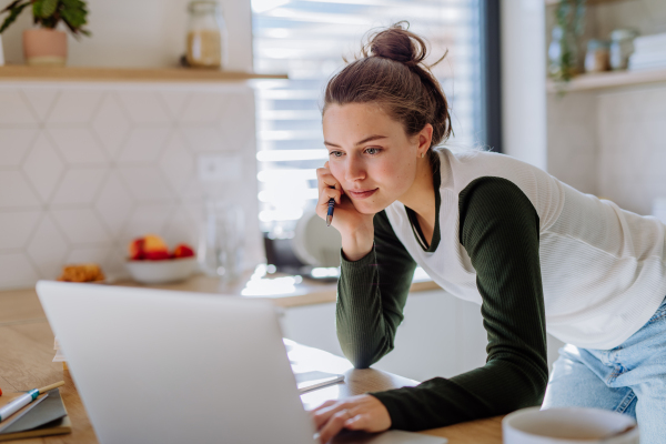 Young woman having homeoffice in a kitchen.