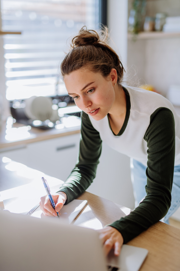 Young woman having homeoffice in a kitchen.