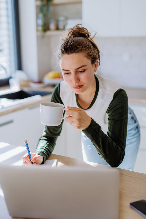 Young woman having homeoffice in a kitchen.