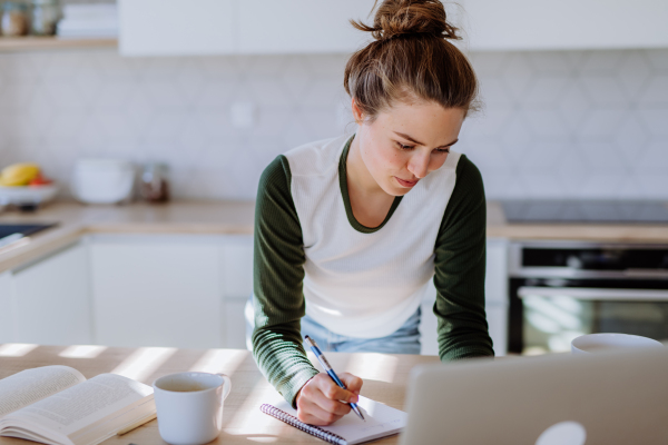 Young woman having homeoffice in a kitchen.