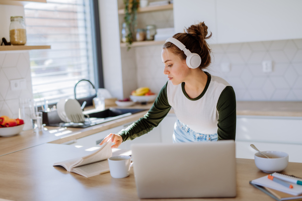 Young woman having homeoffice in a kitchen.