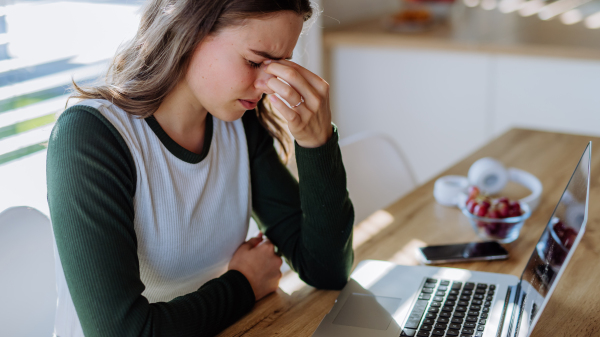 Portrait of a tired woman with laptop, homeoffice concept.