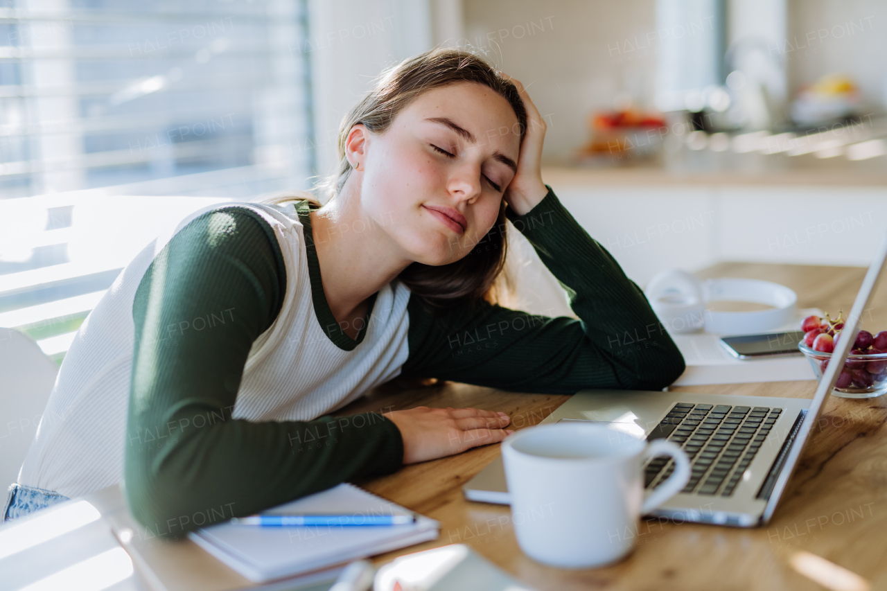 Young woman fall asleep at the table during learning.