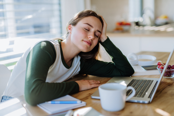 Young woman fall asleep at the table during learning.