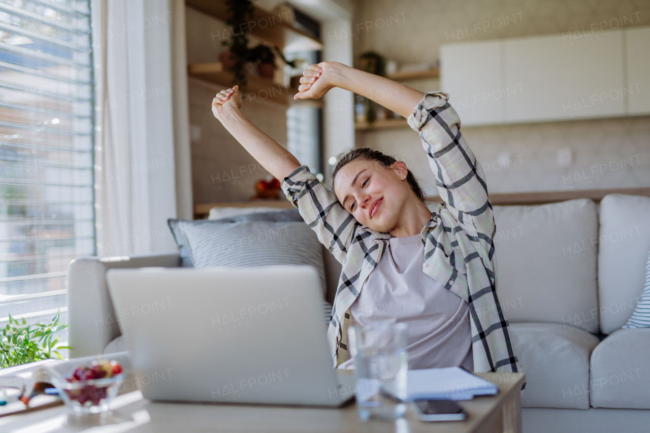 Young woman stretching during homeoffice in an apartment.