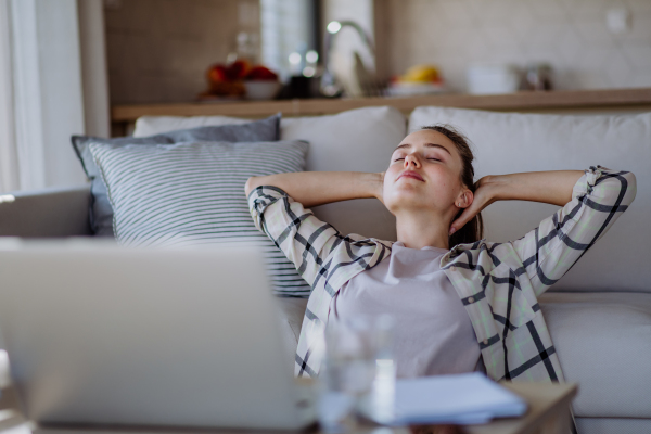 Young woman having break and stretching during homeoffice in an apartment.