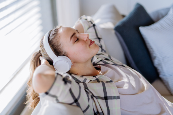 Young woman relaxing with a headphones, listening music.