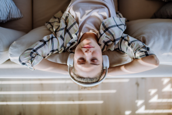 Top view of young woman relaxing with a headphones, listening music.