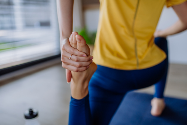 Young woman doing exercises at home, close-up.