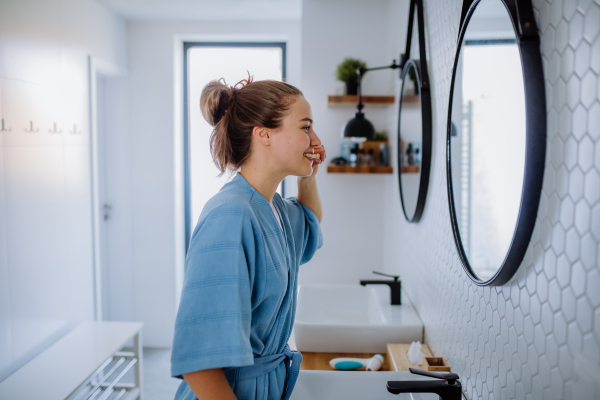 Young woman brushing teeth, morning routine concept.