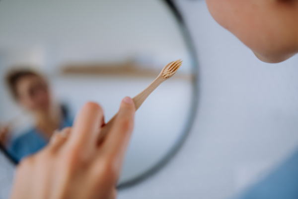 Close-up of a young woman brushing her teeth, morning routine concept.