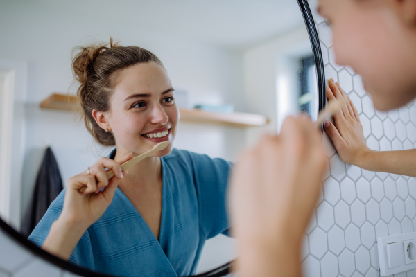 Young woman brushing teeth, morning routine concept.