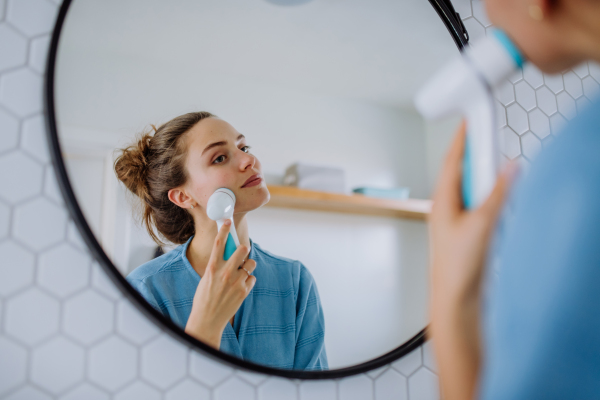 Young woman taking care of her face skin, morning beauty routine concept.