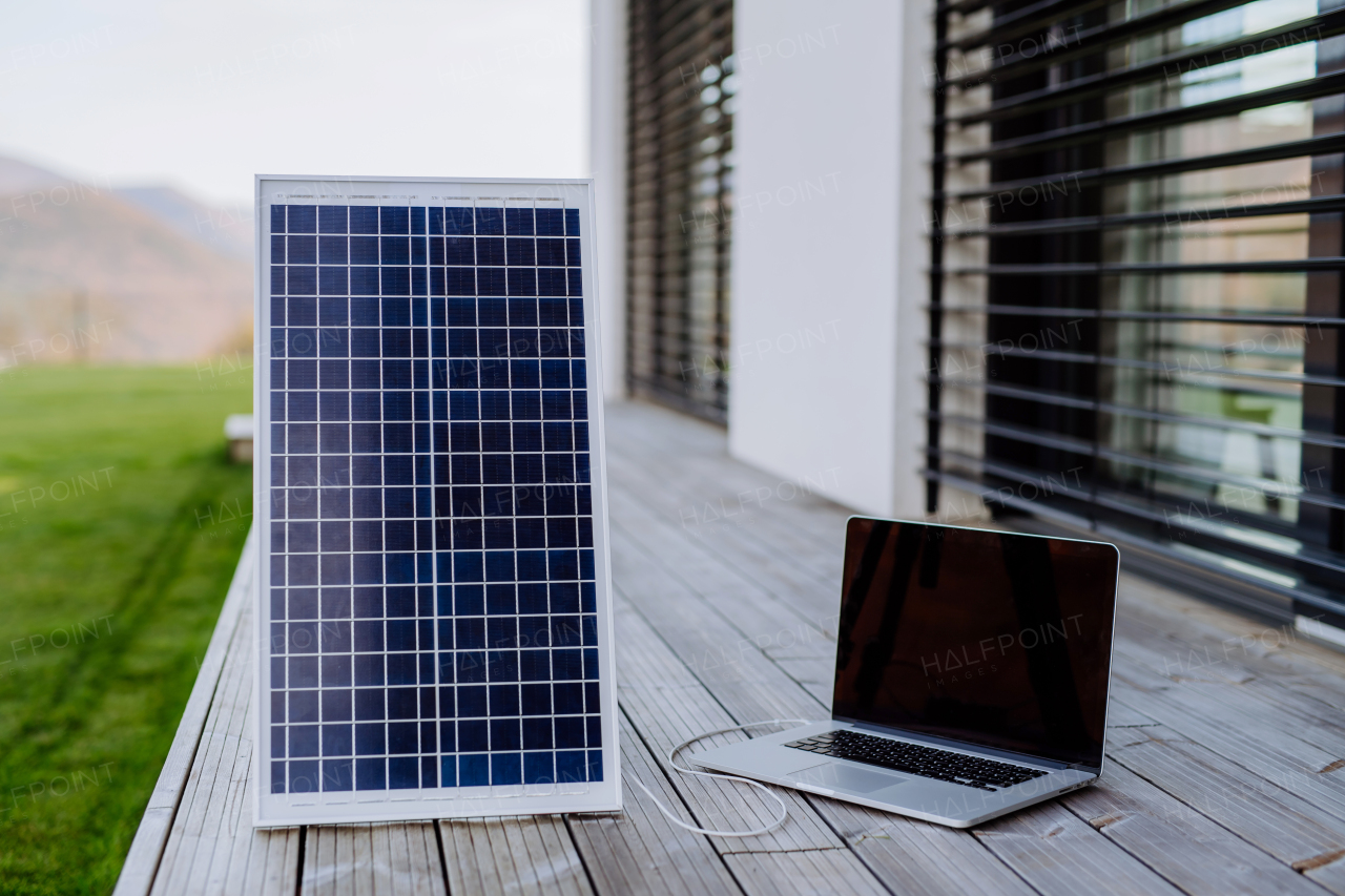 Close-up of laptop charging trough the solar panel.