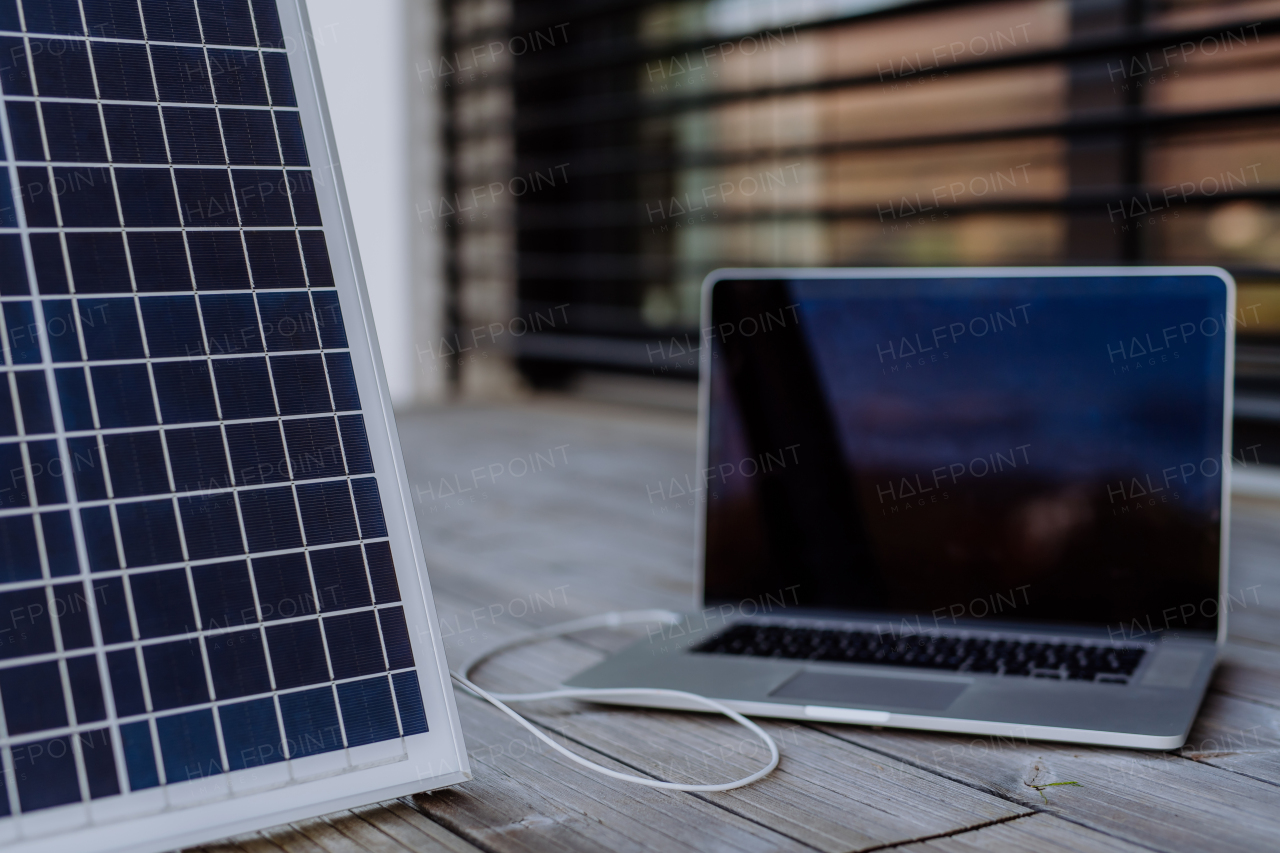 Close-up of laptop charging trough the solar panel.