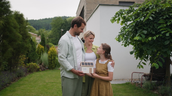 A video of family holding model of house. Sustainable living, green energy in home.