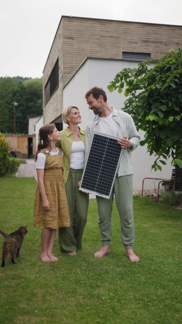 A video of family holding model of solar panel. Sustainable living, green energy in home.