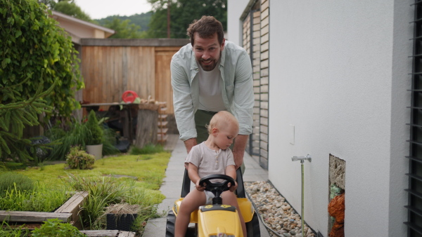 A video of handsome dad and small toddler boy on backyard, garden. Father and young son playing together.