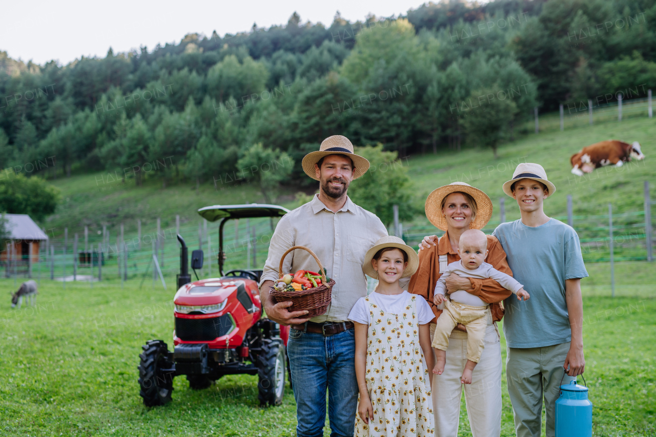 Portrait of farmer family holding harvest basket full of fresh vegetables. Harvesting crops, collecting vegetables on family farm. Concept of multigenerational farming.