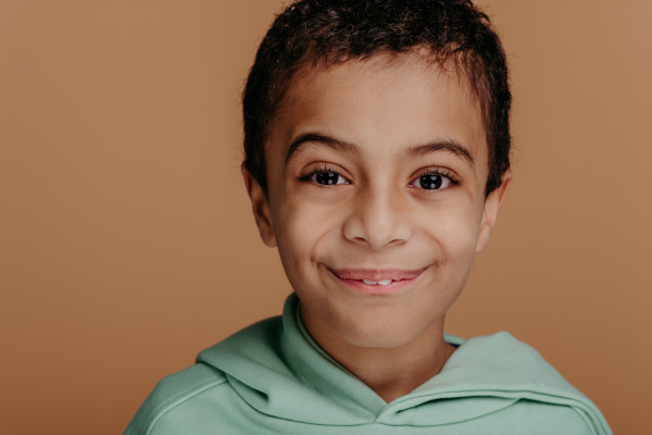 Portrait of a little boy with black hair, studio shoot.