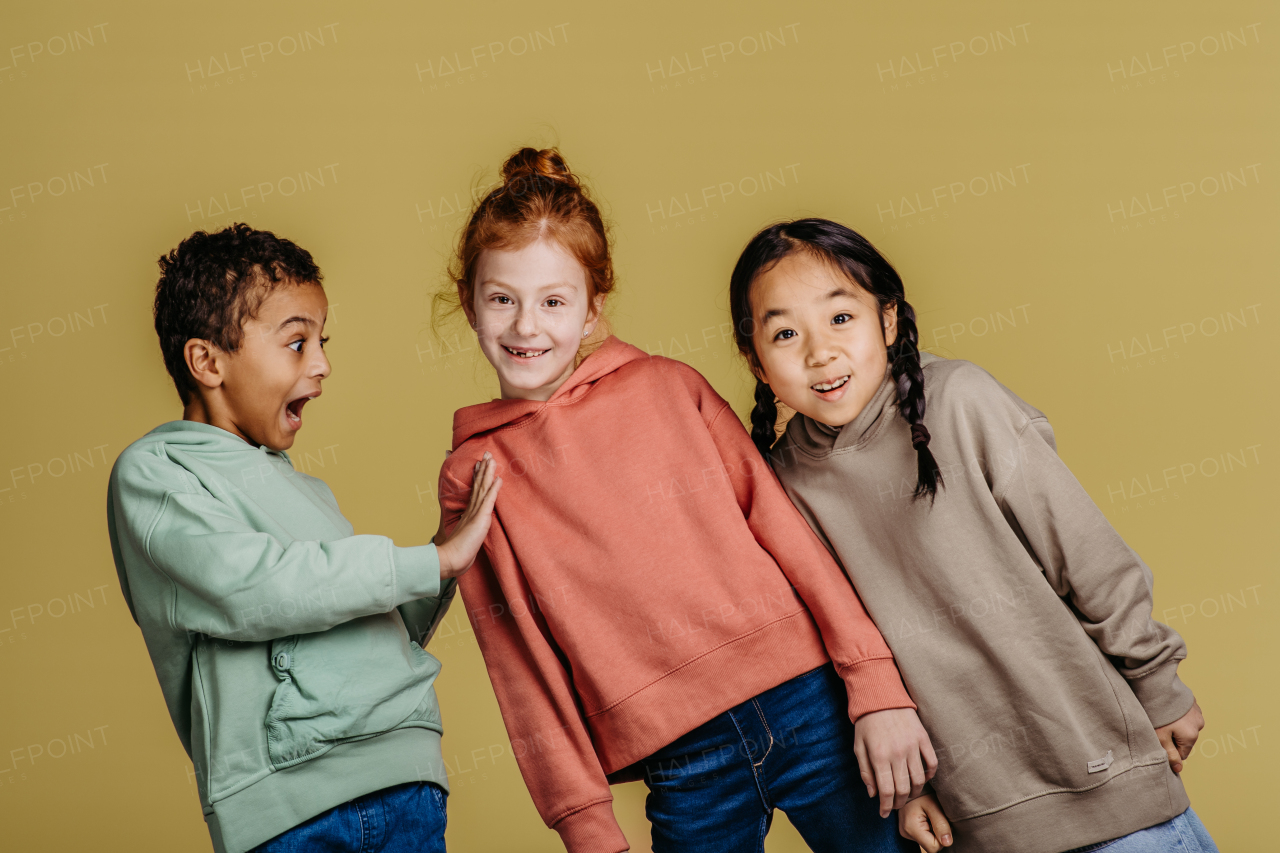 Portrait of three excited children, studio shoot. Concept of diversity in a friendship.