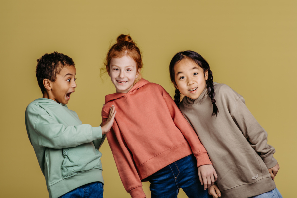 Portrait of three excited children, studio shoot. Concept of diversity in a friendship.