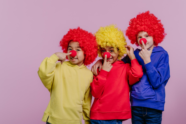 Happy children playing on clown, studio shoot.