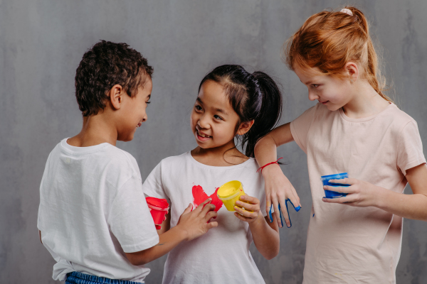 Portrait of happy kids with painted hands, studio shoot.