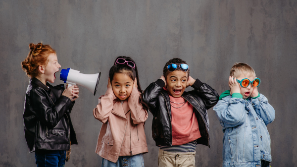 Studio shoot of a child with megaphone shouting at other children.