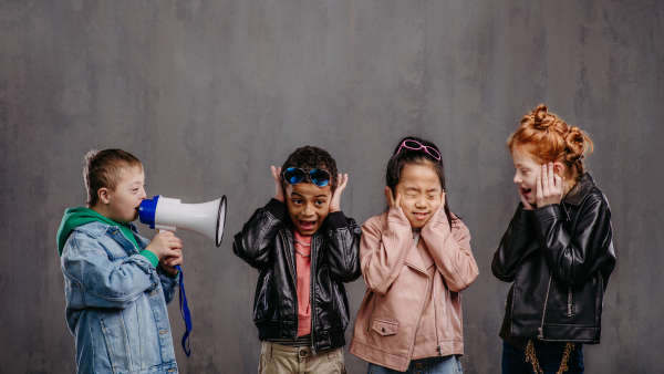 Studio shoot of a child with megaphone shouting at other children.