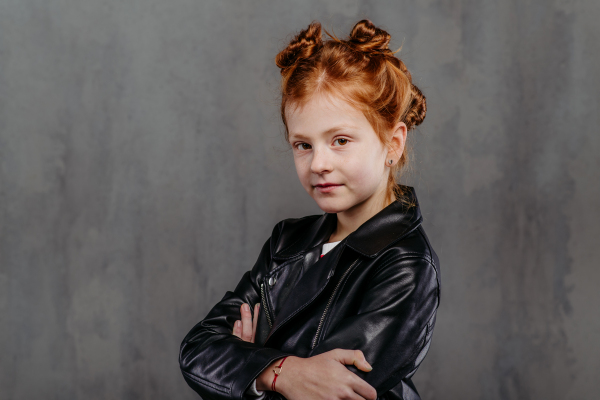 Portrait of little redhead girl with a leather jacket.