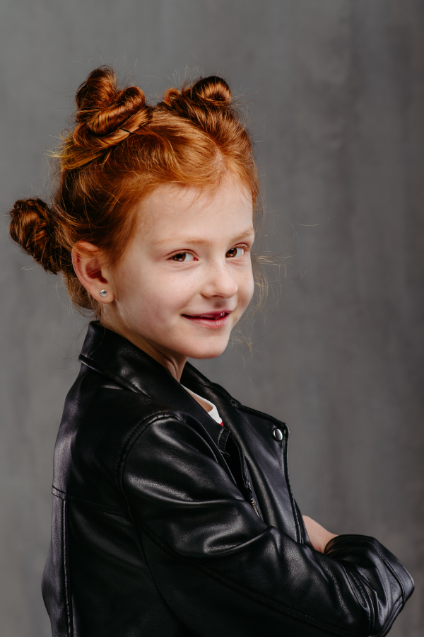 Portrait of little redhead girl with a leather jacket.