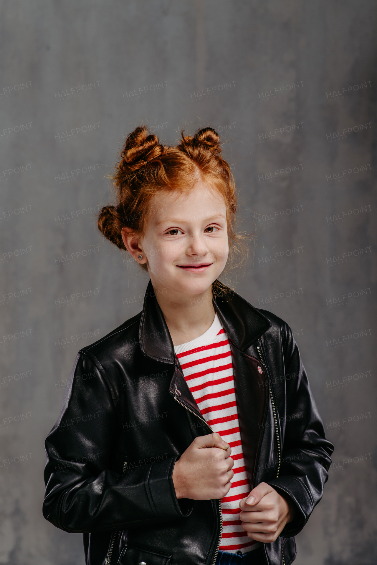 Portrait of little redhead girl with a leather jacket.