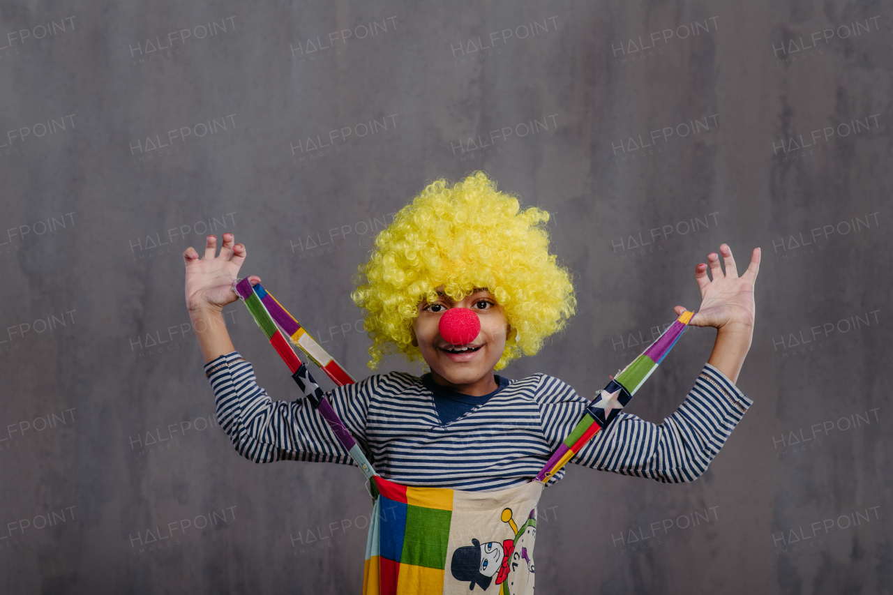 Portrait of little boy in clown costume, studio shoot.