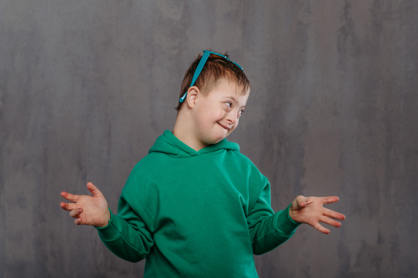 Funny portrait of a little boy with down syndrome, studio shoot.