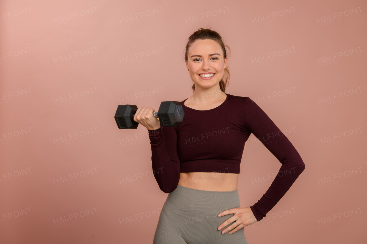 Portrait of young woman in sportive clothes with a medicimbal.