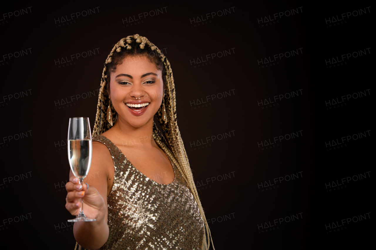 Portrait of happy multiracial woman celebrating with glass of champagne.