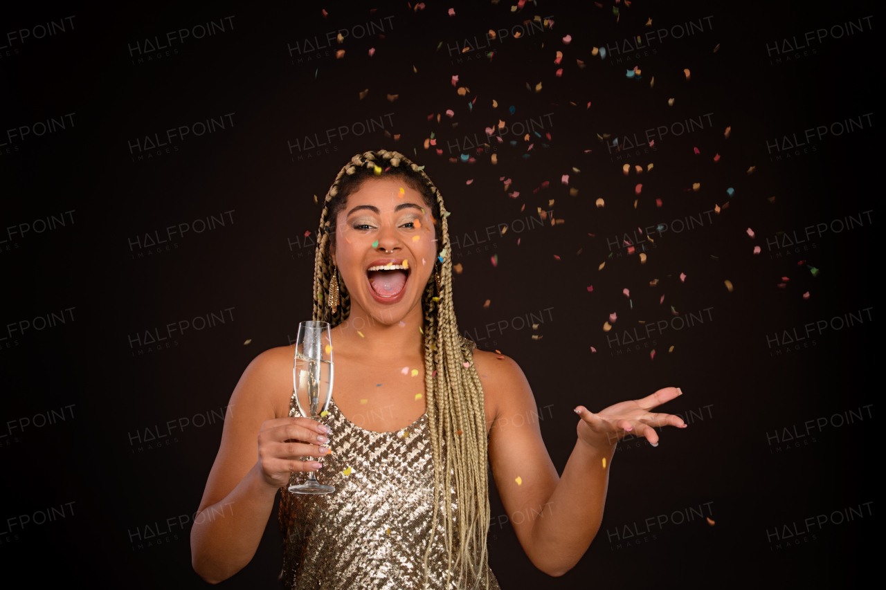 Portrait of happy multiracial woman celebrating with glass of champagne.