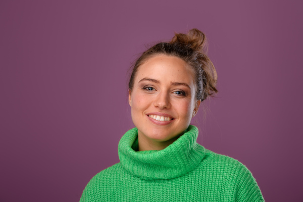 Young happy woman posing in sweater during studio shooting.